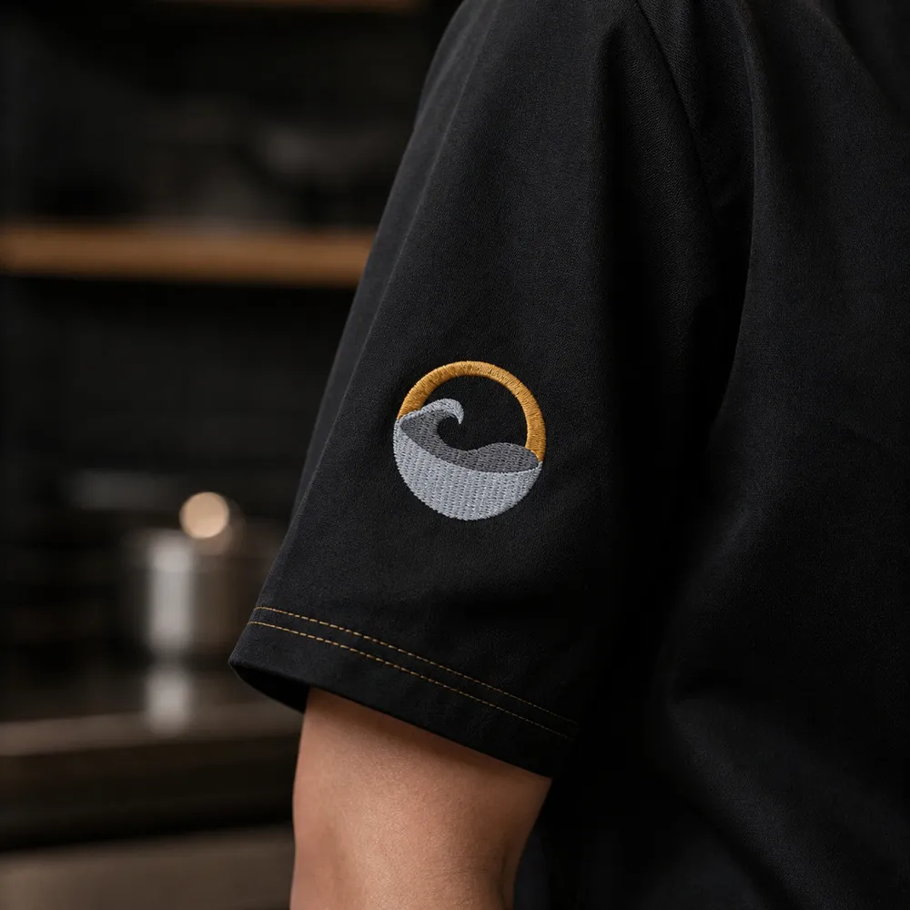 黑色工作服袖口客製化Logo刺繡，透過多色繡線呈現細緻圖案與